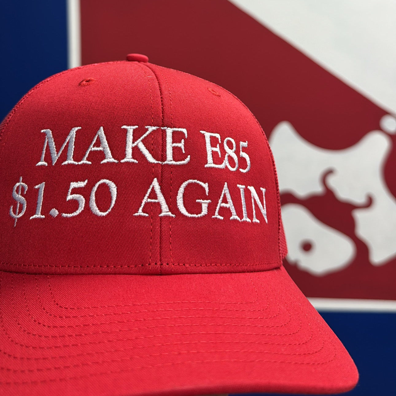 Red cap with 'MAKE E85 $1.50 AGAIN' text in front of a blue and white logo.